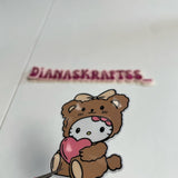 Cartoon bear with a heart and 'DIANASKRAITSS' text on a white background