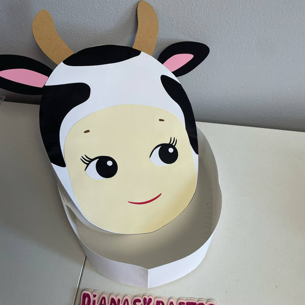Cow-themed paper mask on a white surface with 'Dianaskrafts' branding.